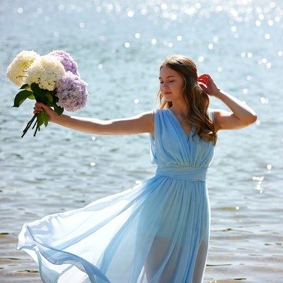 Woman holding flowers by the water