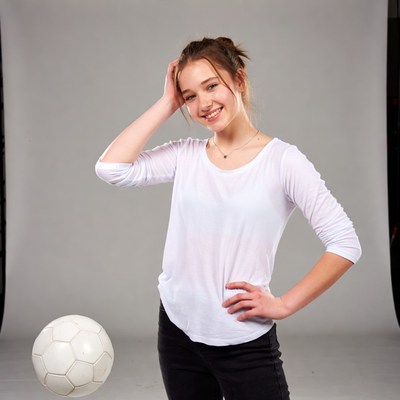 Smiling girl poses with soccer ball