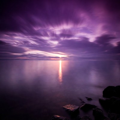 Sunset over still water with clouds