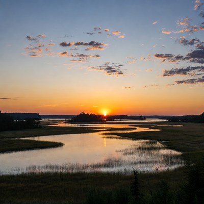 Sunset over calm waters and marshlands
