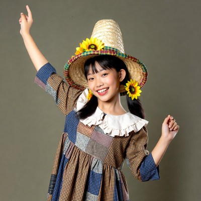 Girl in straw hat poses with sunflowers