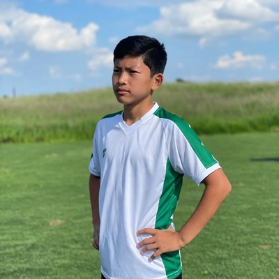 Young soccer player poses on field