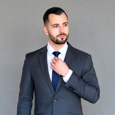 Professional man adjusting tie indoors