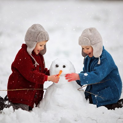 Kids build snowman in winter fun