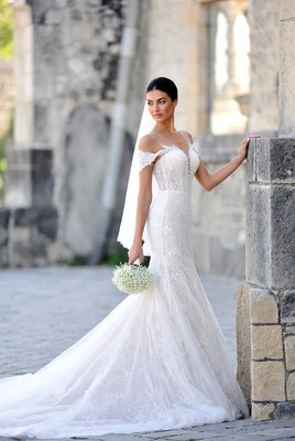 Bride posing with bouquet outside building