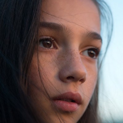 Young girl looking thoughtfully outdoors