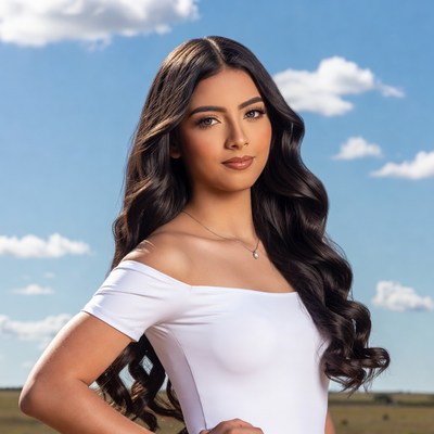 Young woman poses outdoors under blue sky