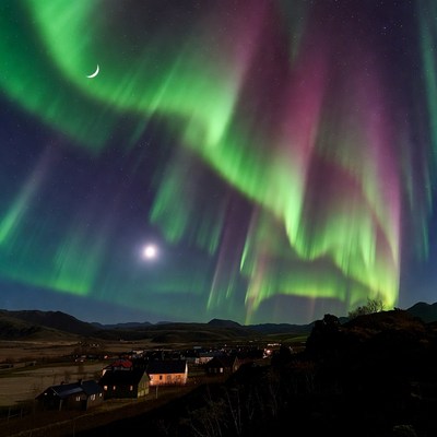Aurora lights shine over the valley at night