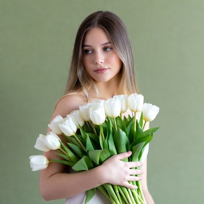 Woman holding white tulips indoors