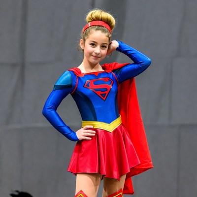 Girl in superhero costume poses confidently