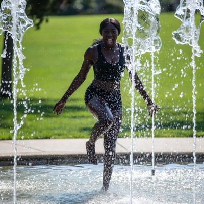 Woman playing in water fountain