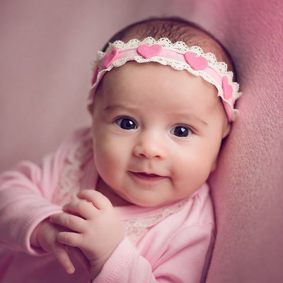 Baby with pink headband smiles