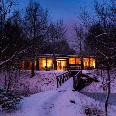 Winter cabin at dusk with warm lights