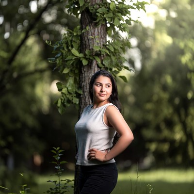 Woman poses near tree in park