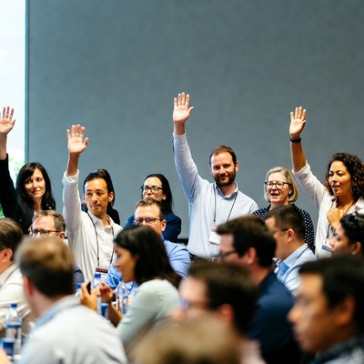 People raising hands at a meeting