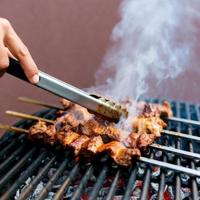 Grilling meat on skewers over hot coals