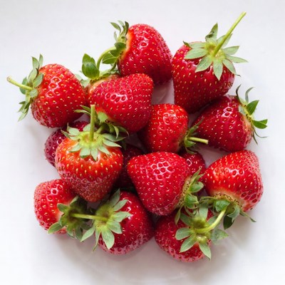 Fresh strawberries on white surface