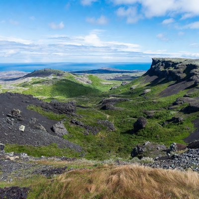 Landscape of volcanic rock and green hills