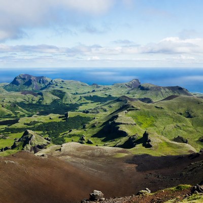 Green hillsides overlook vast ocean view