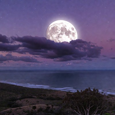 Bright moon over ocean at night