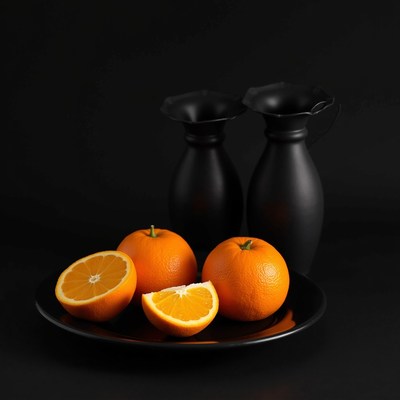 Oranges on black plate with vases