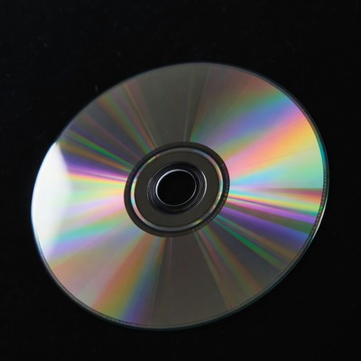 Cd reflecting light on black surface