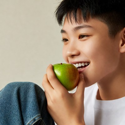 Smiling child holding green apple