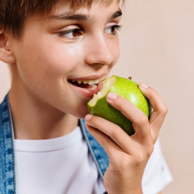 Boy enjoying green apple at home