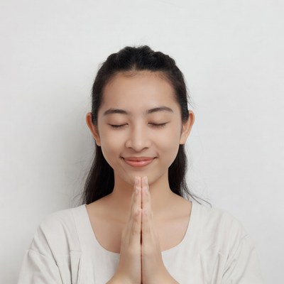Young woman with hands in prayer position