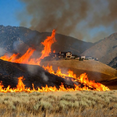 Fire spreads across hills near houses