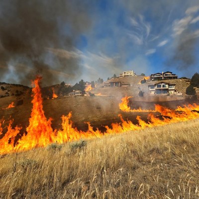 Wildfire spreads near homes in hillside