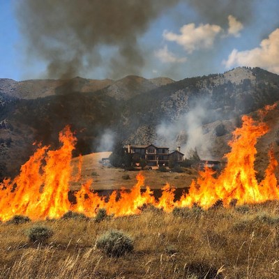 Fire spreads near a house on a mountain
