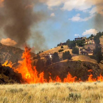 Fire spreads across the hillside near homes