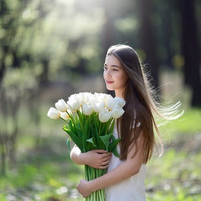 Girl holding white tulips in a forest