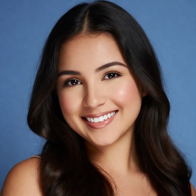 Smiling woman with dark hair and blue background