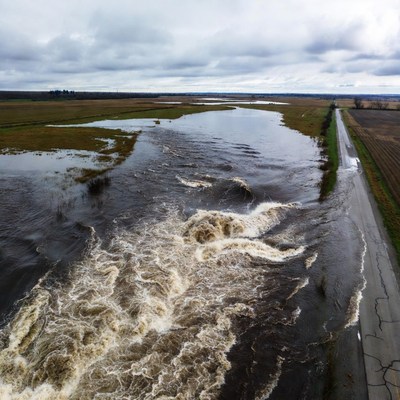 River flows along road during cloudy day