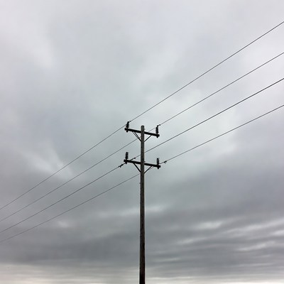 Power lines against cloudy sky