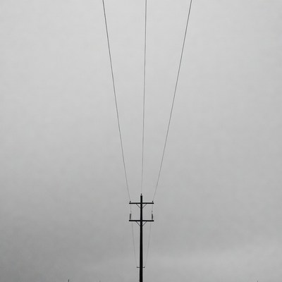 Power lines under cloudy sky
