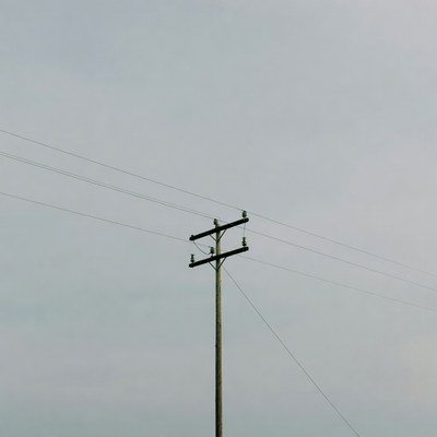 Power pole against gray sky