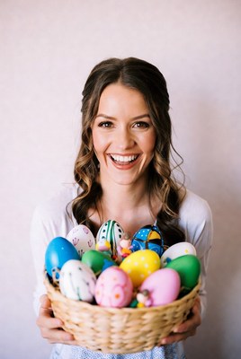 Smiling person holding colorful eggs
