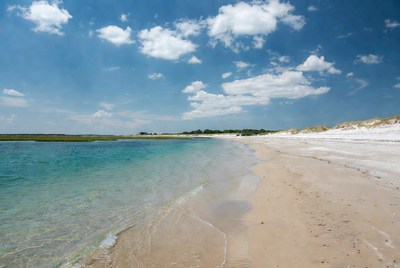Clear water and sandy beach under blue sky