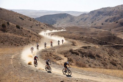Cyclists riding through dusty landscape