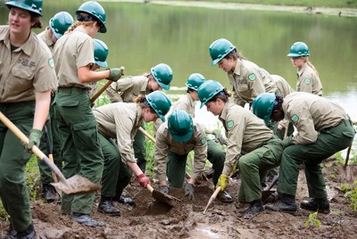 Youth group planting trees by river