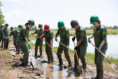 Group of workers digging in wet soil