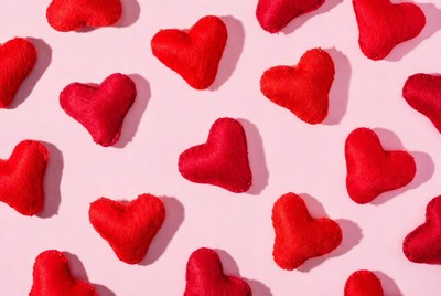Red fabric hearts on pink background