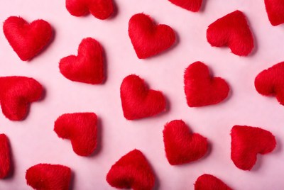 Red hearts scattered on pink surface