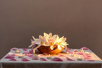 Flower petal arrangement with candles on table
