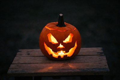 Orange pumpkin with glowing face at night
