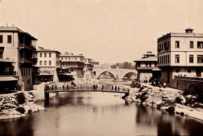 People by the river near old buildings
