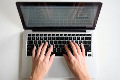 Typing on a laptop at a desk